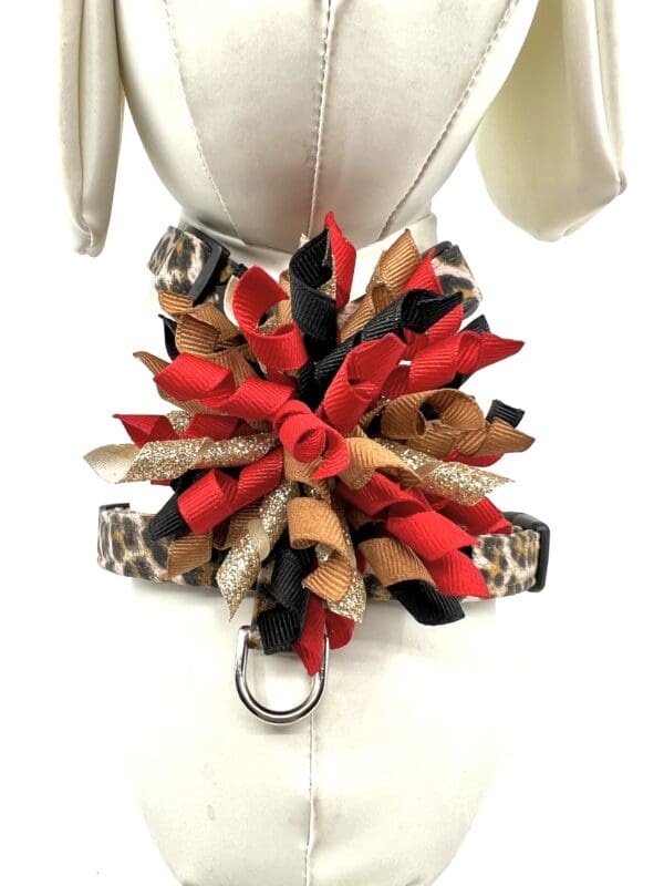 A red, black and brown dog harness with a ring around it.