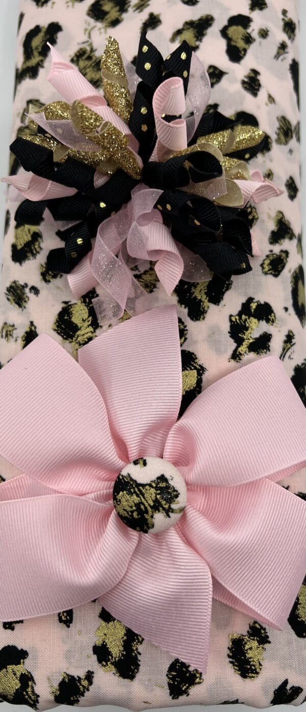 A pink and black leopard print cover with a bow.