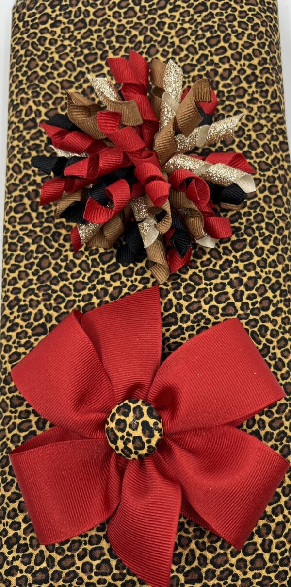 A red bow and leopard print fabric on top of a table.