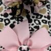 A close up of the bow on a leopard print blanket