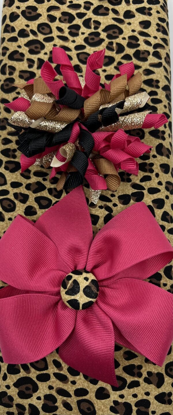 A close up of two bows on top of a leopard print bag.