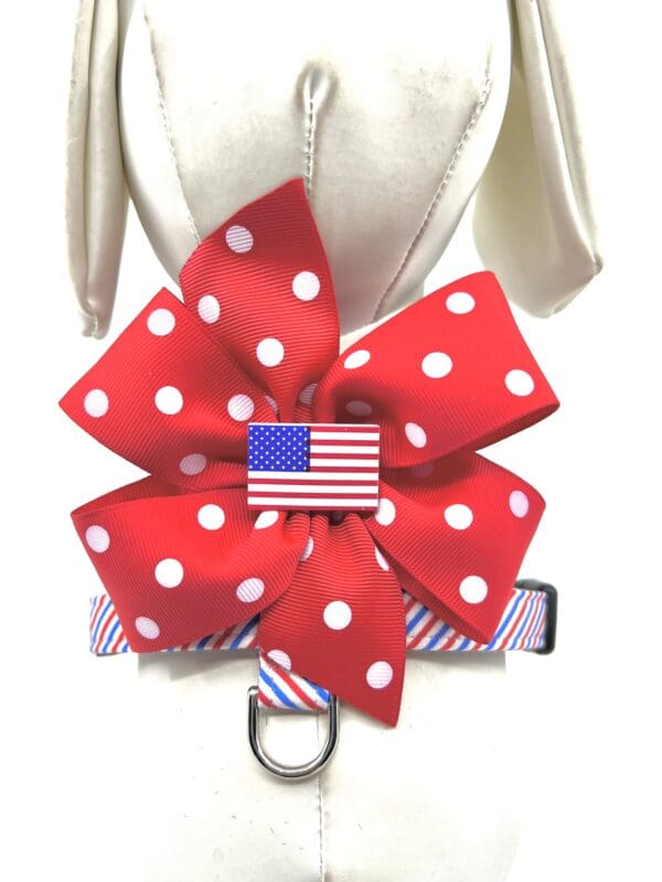 A dog collar with a red, white and blue bow.