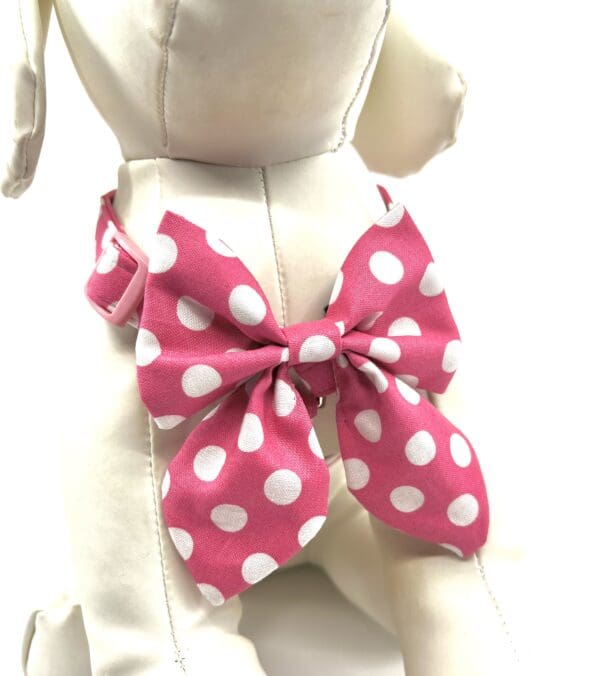 A pink and white polka dot bow tie on a dog.