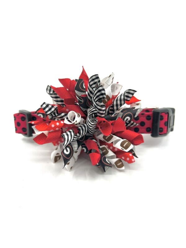 A red and black dog collar with a zebra print bow.