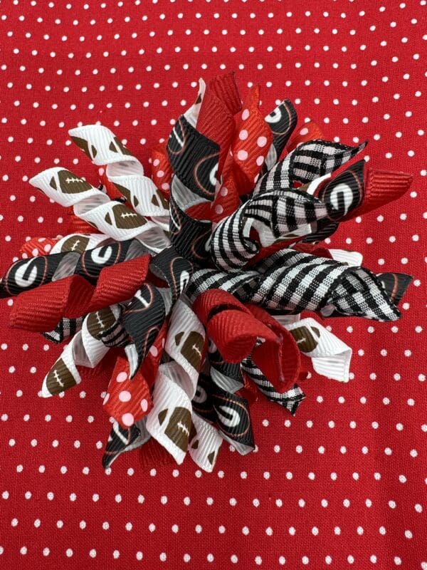 A red and white polka dot fabric with a black, brown and white flower.