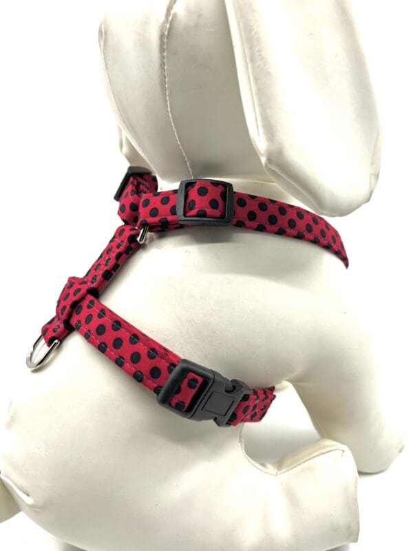 A red and black polka dot harness for dogs.