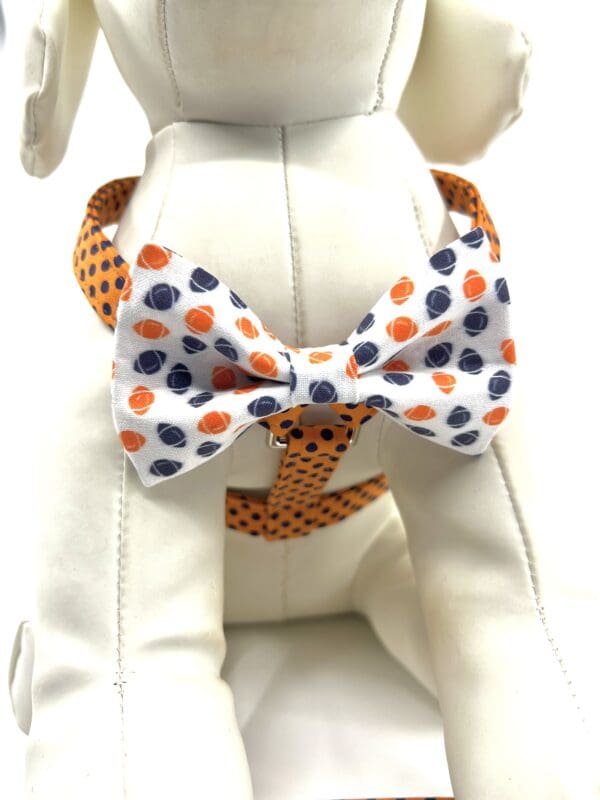 A dog wearing a bow tie with orange and blue polka dots.