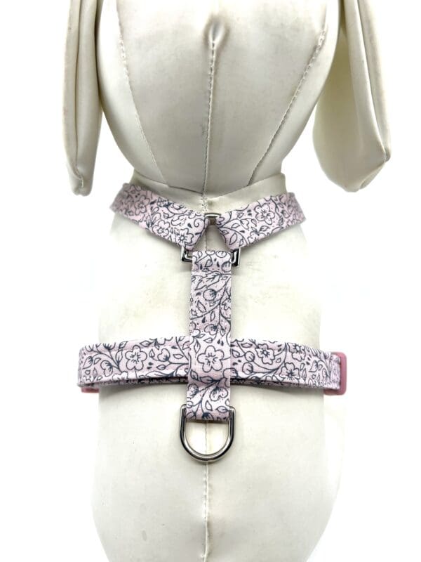 A white dog harness with a floral pattern.