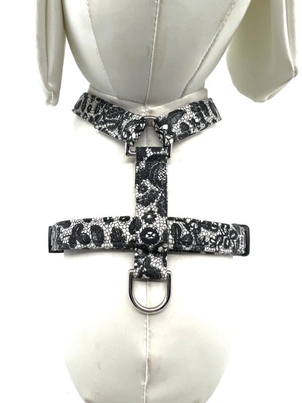 A white and black harness with a bow on it
