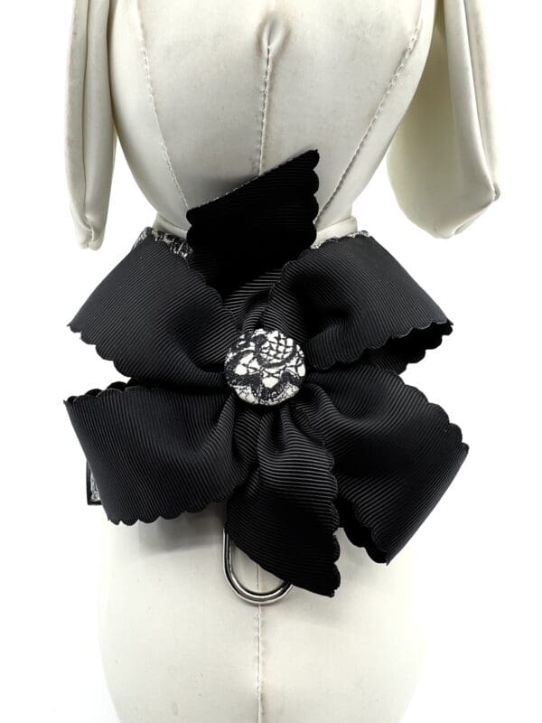 A black bow with a silver flower on it.