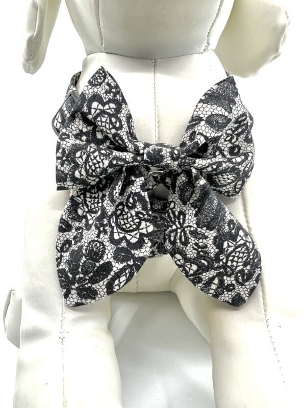 A black and white bow tie sitting on top of a dog.