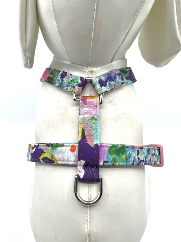 A dog harness with colorful flowers on it.