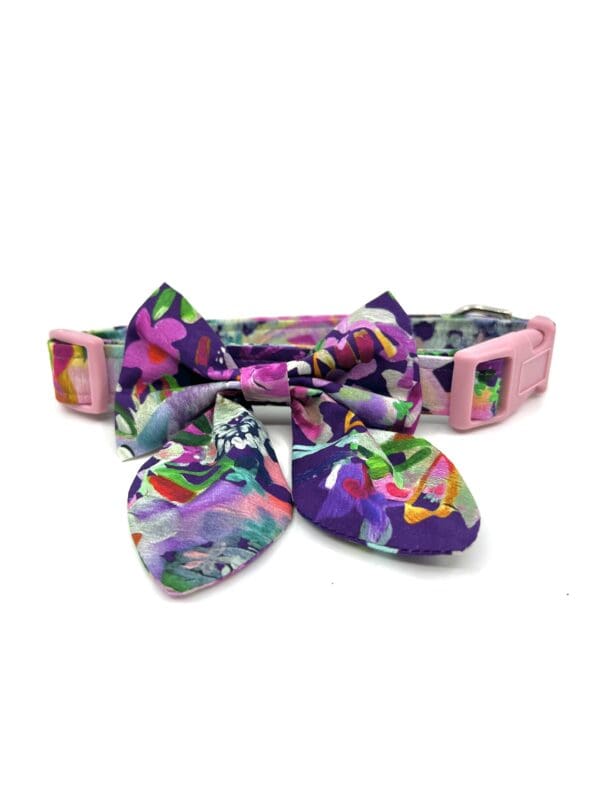 A dog collar with a colorful bow on it.