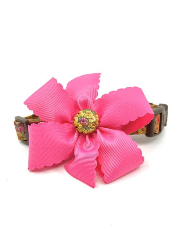 A pink flower is sitting on top of a brown bracelet.