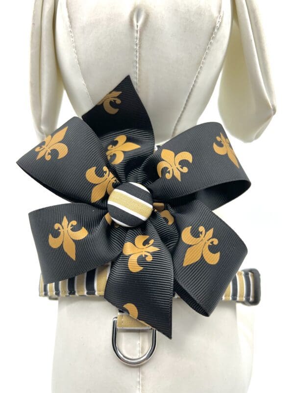 A black and gold bow on a dress form.