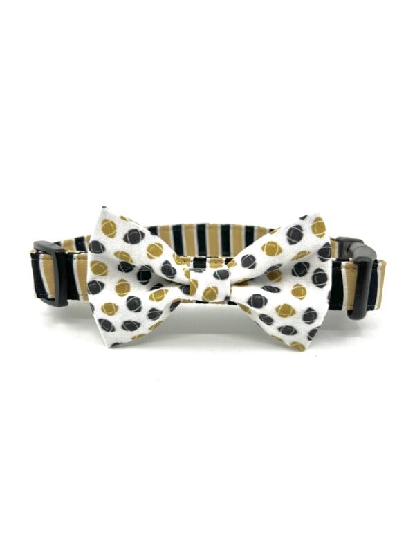 A black and gold bow tie with polka dots.