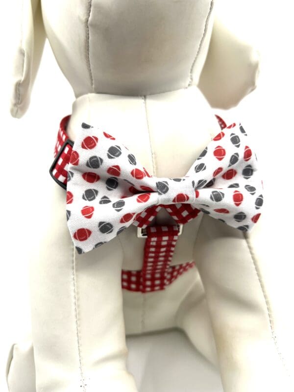 A dog wearing a bow tie and a red, white and black polka dot bow tie.