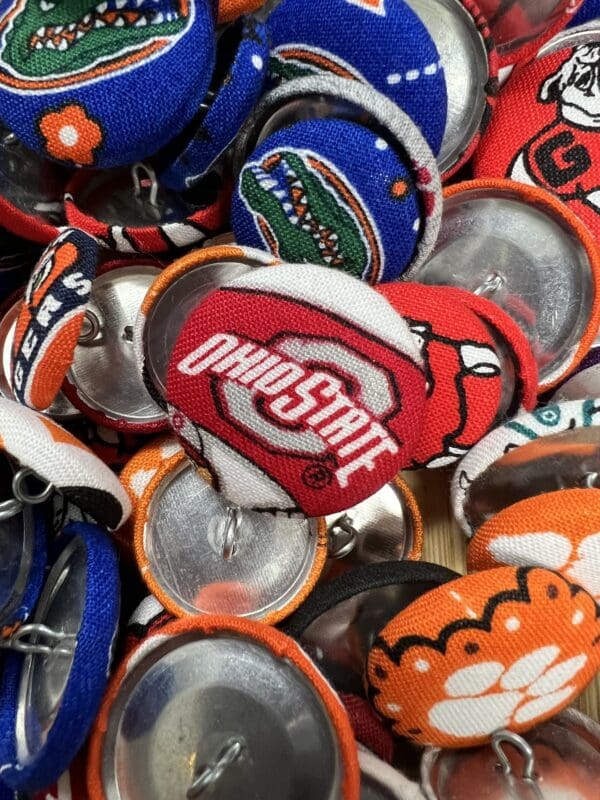 A pile of beer caps with different teams on them.