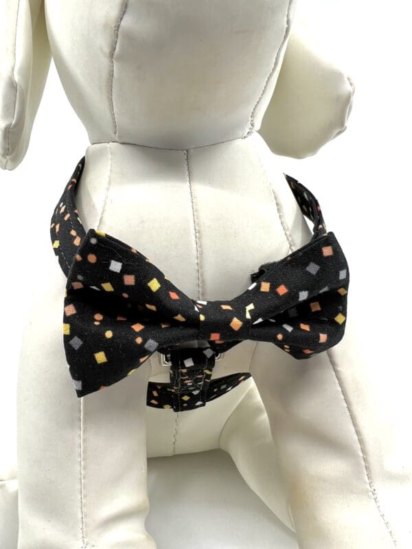 A dog wearing a bow tie with colorful dots.
