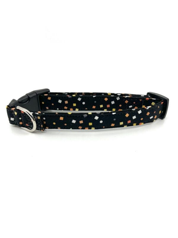 A black collar with white and yellow dots on it.