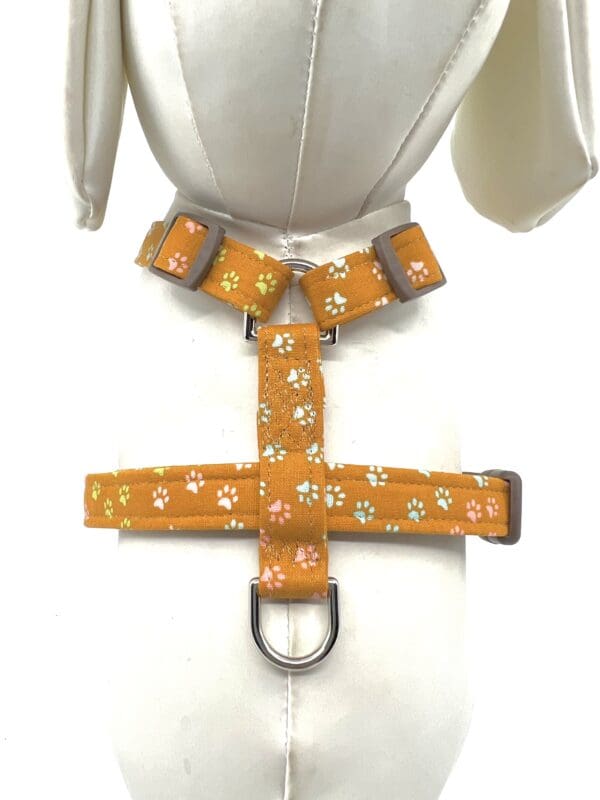 A dog harness with a white paw print pattern.
