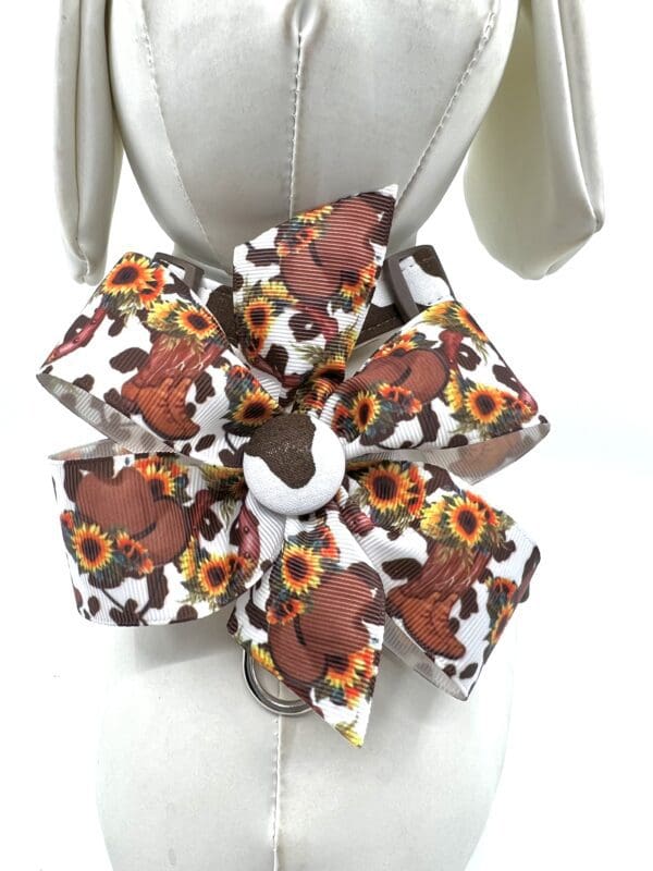 A white dress with a brown cow print bow.