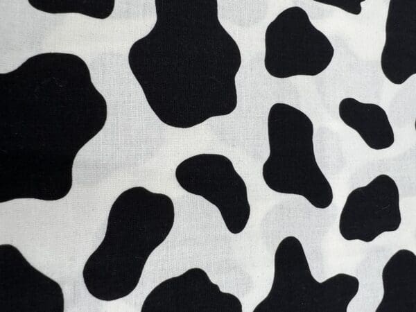 A close up of the cow print on a pillow