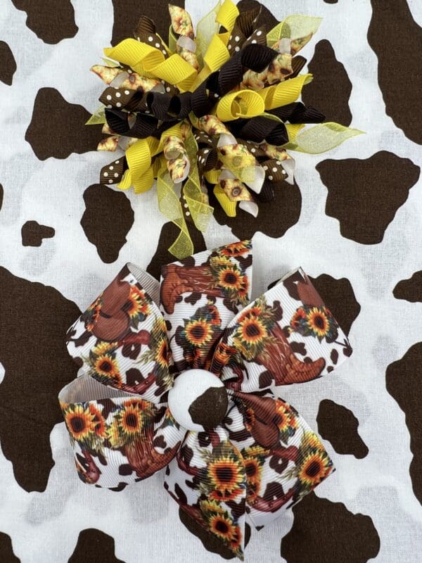 A brown and white cow print table cloth with sunflowers.