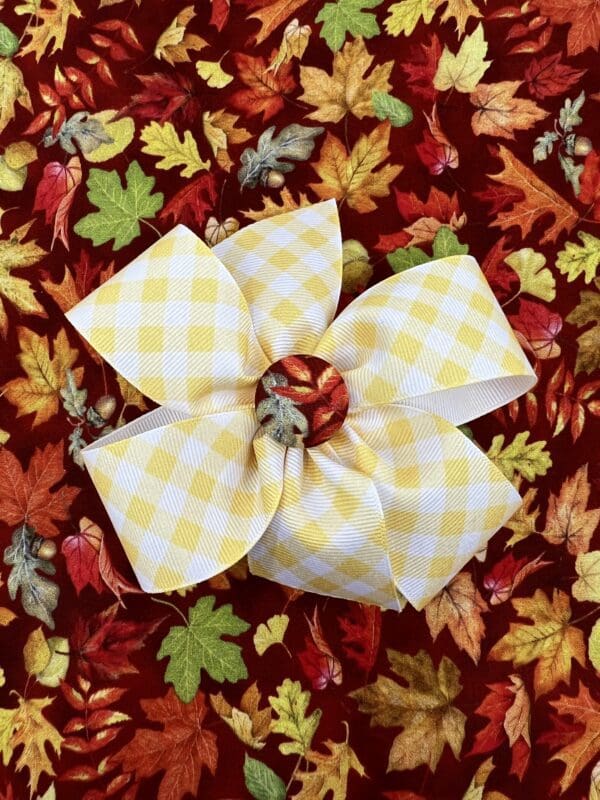 A yellow and white bow on a fall background