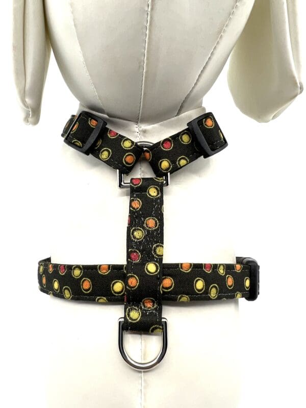 A black harness with yellow and red circles on it.
