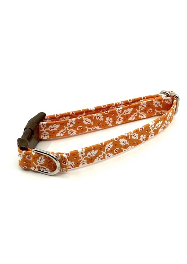 A dog collar with an orange and white pattern.