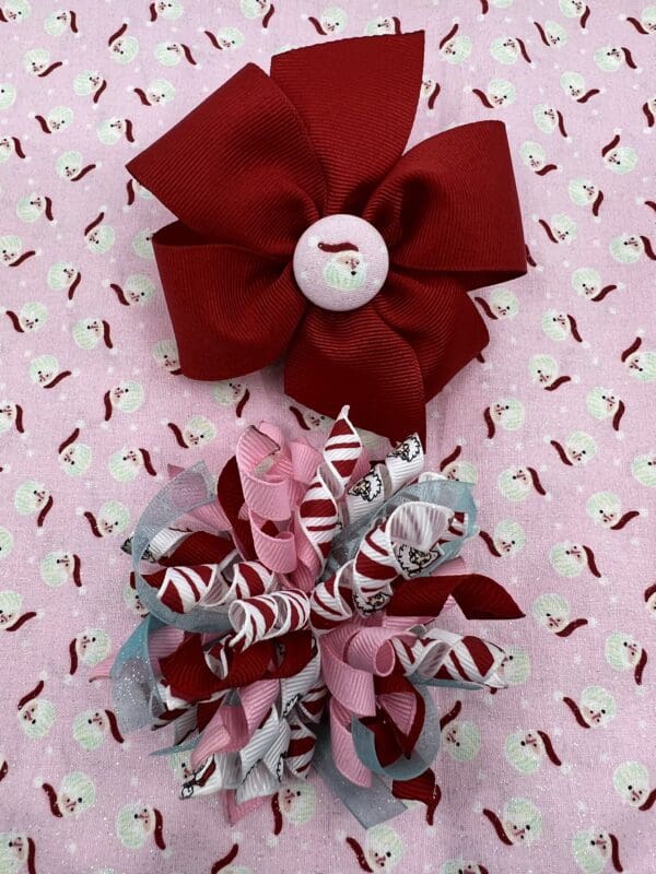 Two red and white bows on a pink background.