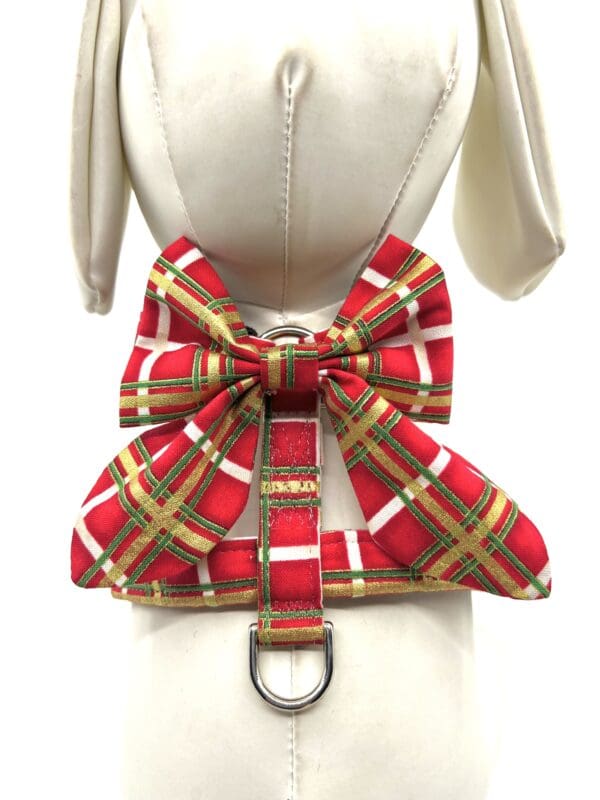 A mannequin wearing a red plaid bow tie dog harness.