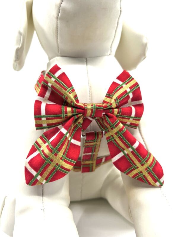A dog wearing a red and green plaid bow tie.