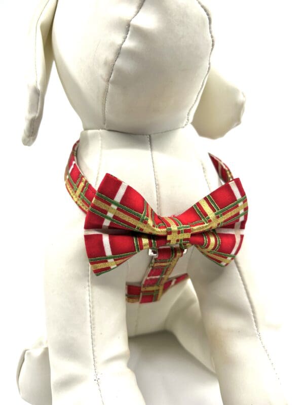 A dog wearing a red and white plaid bow tie.