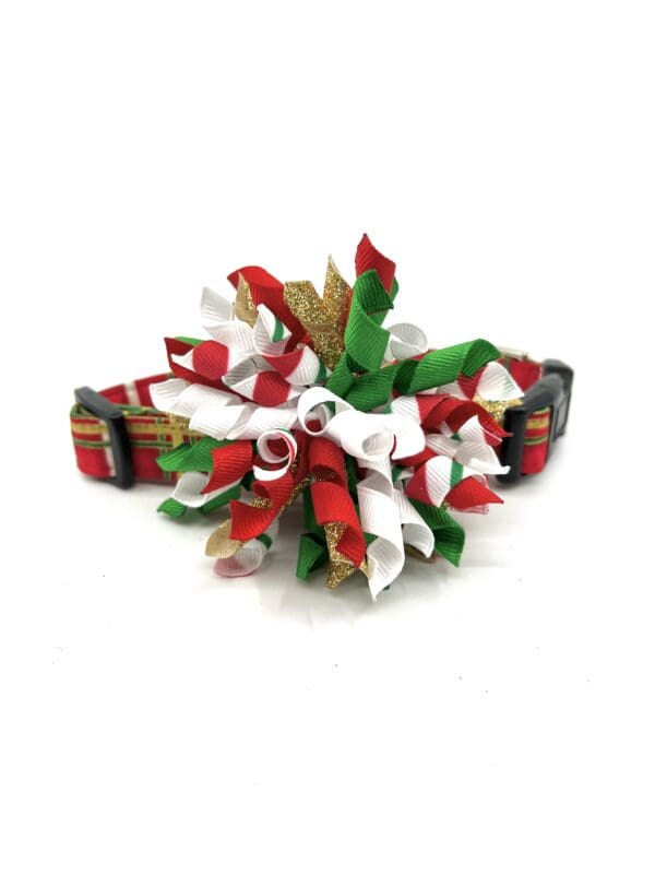 A dog collar with red, green, and white ribbons.