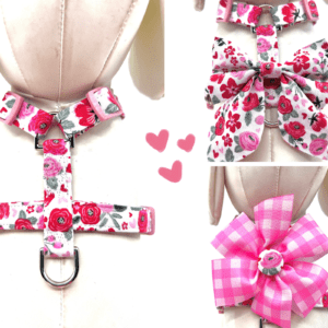 A dog harness with pink flowers and bows.