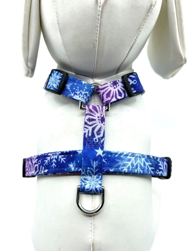 A blue and purple dog harness with a snowflake pattern.