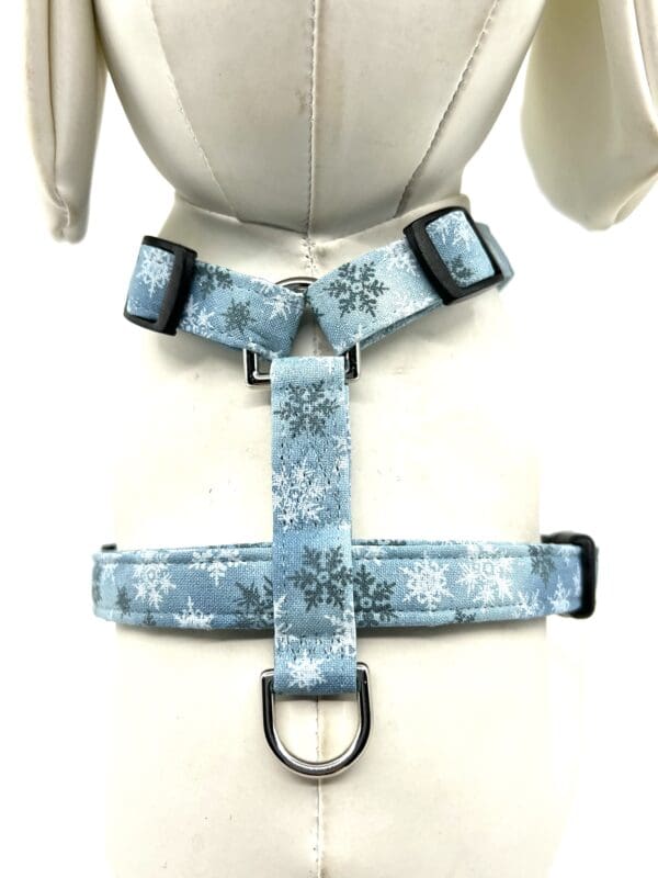 A blue dog harness with snowflakes on it.