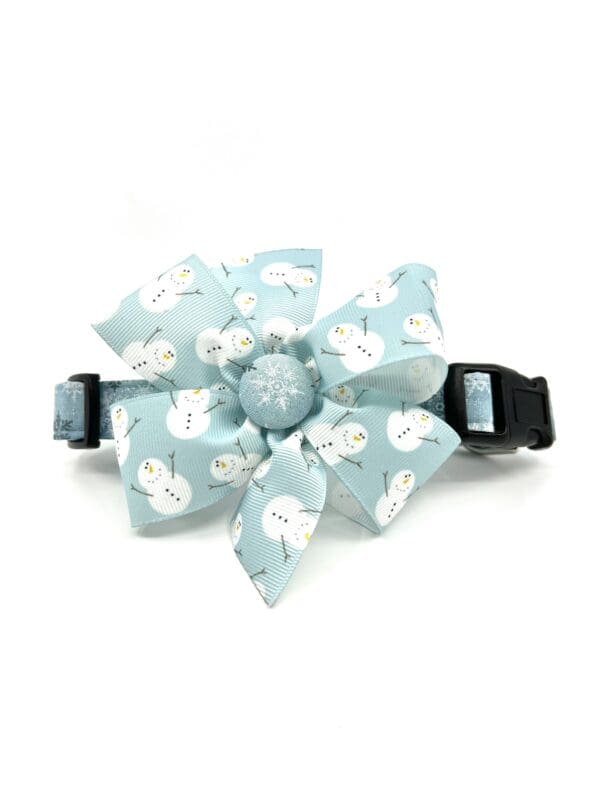 A blue dog collar with white snowflakes on it.