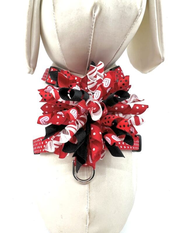 A mannequin wearing a red and black ribbon collar.