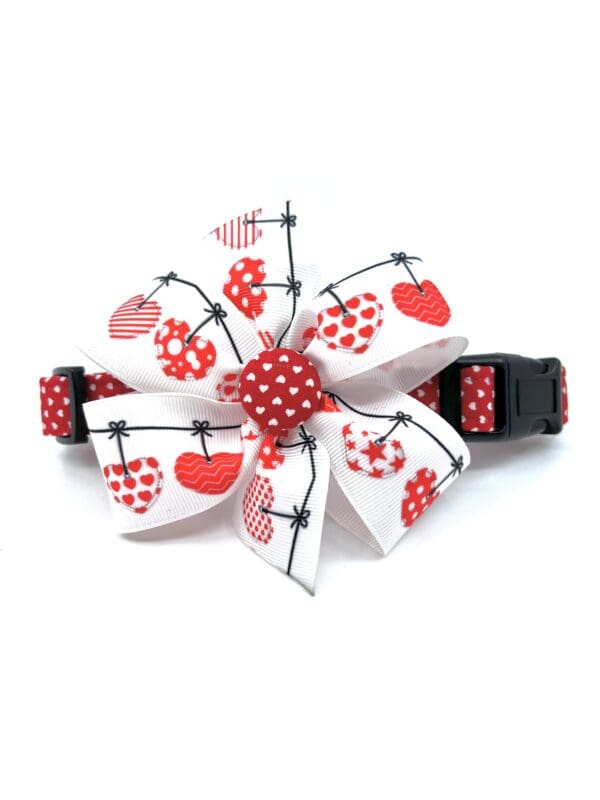 A red and white polka dot dog collar with hearts on it.