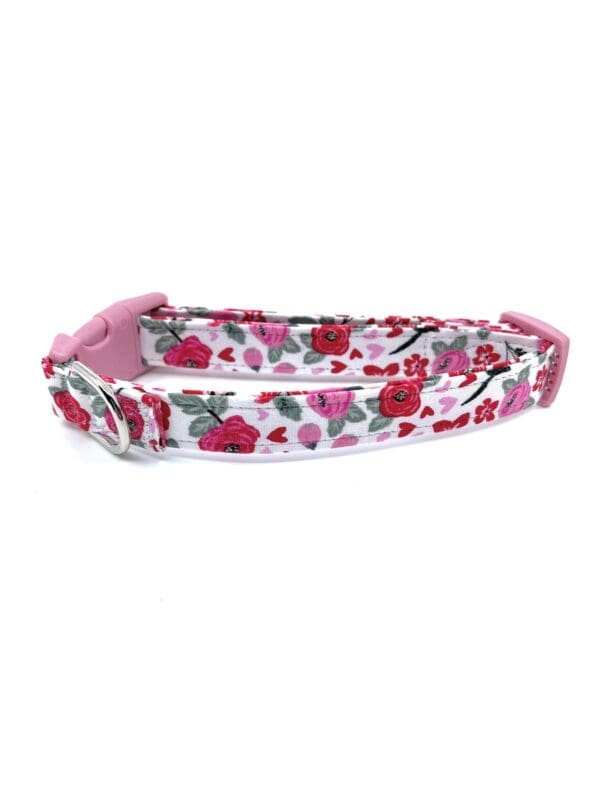 A dog collar with a pink handle.