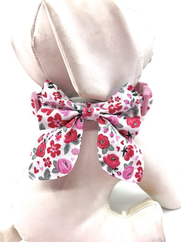 A pink bow tie on a mannequin.