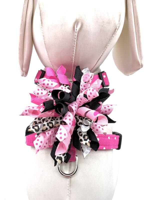 A mannequin with a pink and black collar and bows.