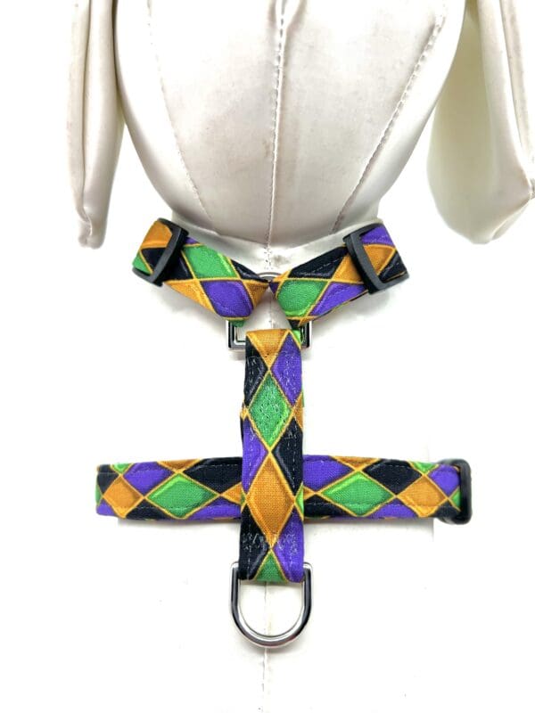 A mannequin wearing a purple, green, and yellow harness.